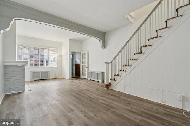 unfurnished living room featuring radiator and wood-type flooring