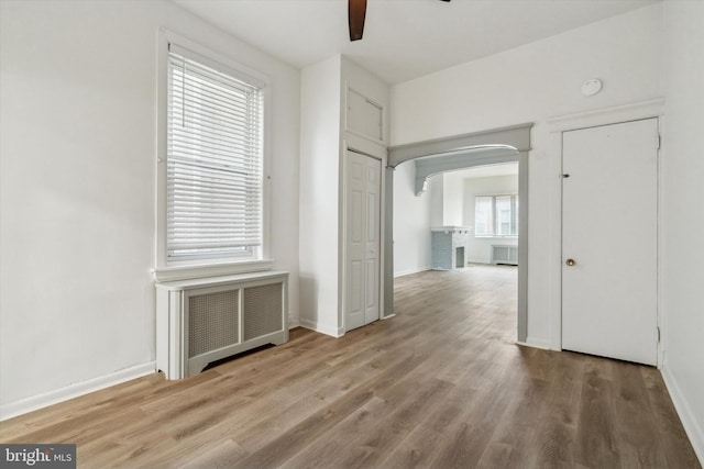 hallway featuring wood-type flooring and radiator heating unit