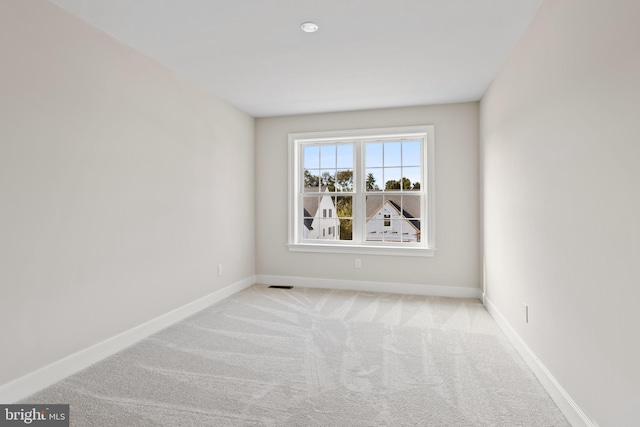 spare room featuring light carpet