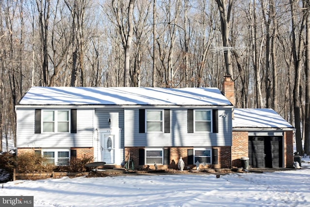 bi-level home with a chimney and brick siding