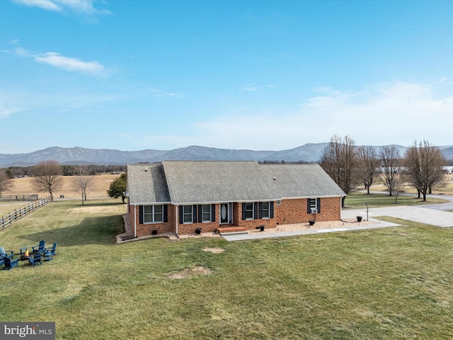 view of front of house with a mountain view and a front yard