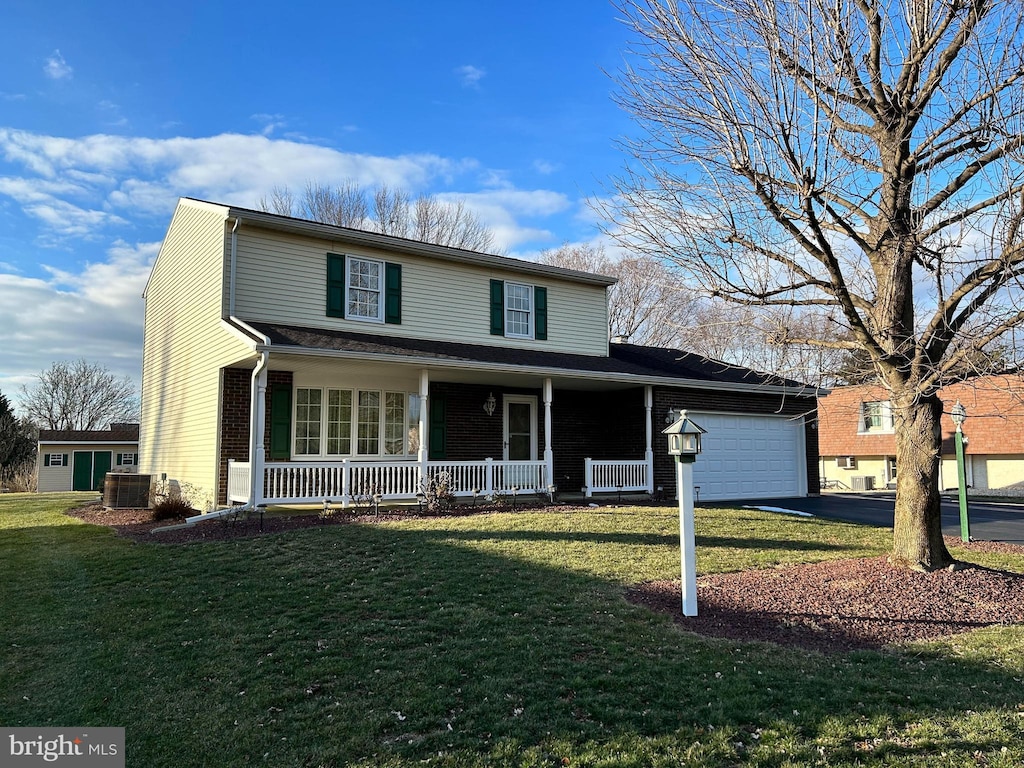 view of front property with central AC, a garage, covered porch, and a front lawn