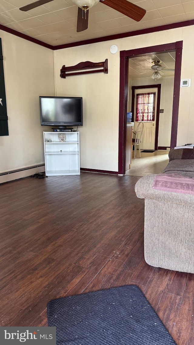 unfurnished living room with a baseboard heating unit, crown molding, and hardwood / wood-style flooring