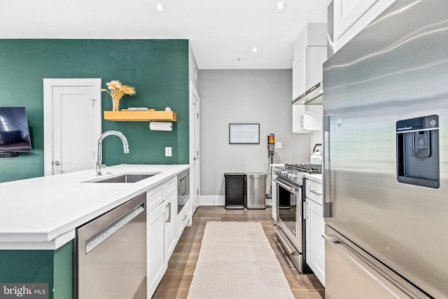 kitchen featuring sink, white cabinetry, appliances with stainless steel finishes, and wood-type flooring