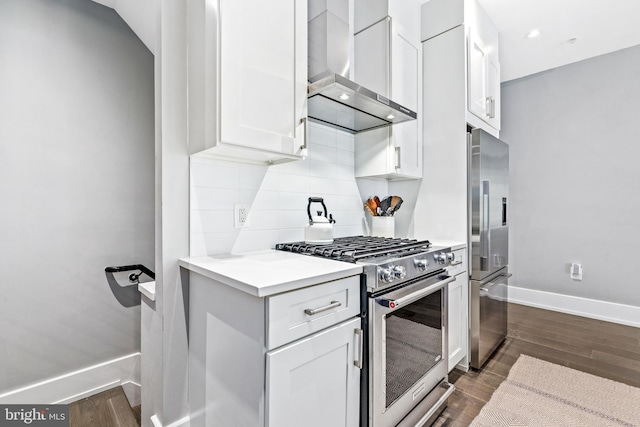 kitchen featuring white cabinets, dark hardwood / wood-style floors, stainless steel appliances, and wall chimney exhaust hood