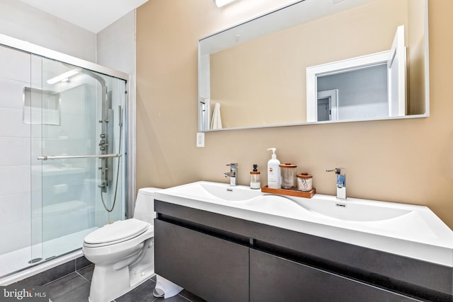 bathroom with a shower with shower door, toilet, vanity, and tile patterned flooring