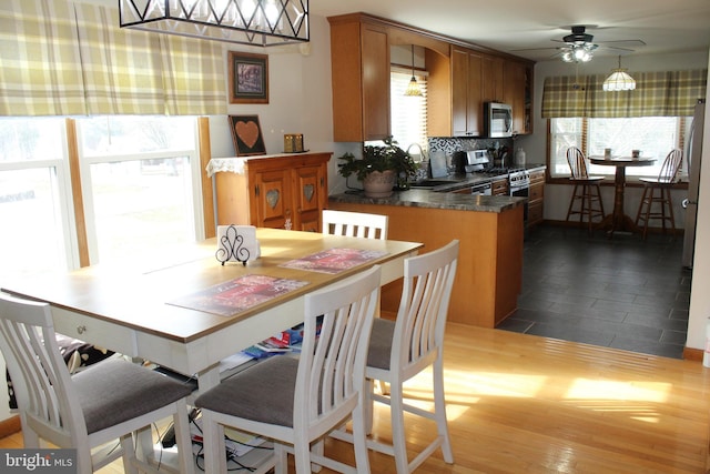 dining space with ceiling fan and sink