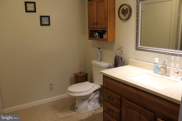 bathroom with toilet, vanity, and tile patterned flooring