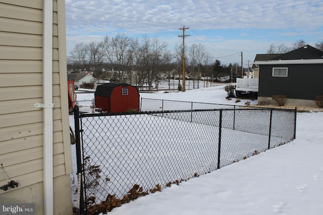 yard layered in snow with a storage shed