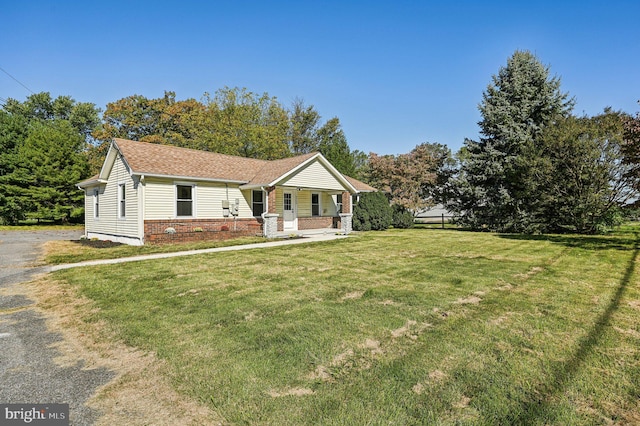 ranch-style house with covered porch and a front yard