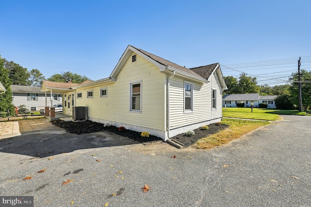 view of home's exterior with central AC unit and a yard