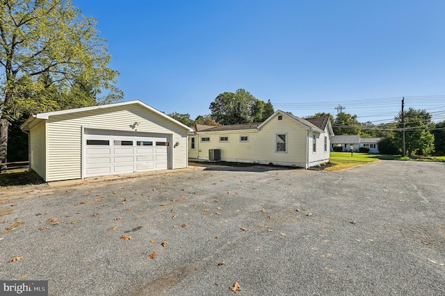 view of front of home with central AC, an outdoor structure, and a garage