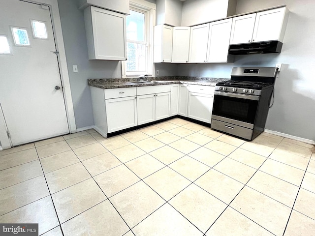 kitchen featuring stainless steel gas stove, sink, white cabinetry, and light tile patterned flooring