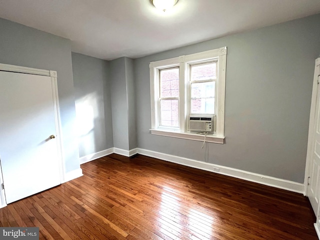 spare room with cooling unit and wood-type flooring