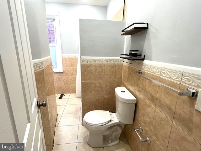 bathroom featuring tile patterned floors, tile walls, and toilet