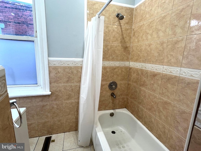 bathroom with tile patterned flooring, tile walls, and shower / tub combo