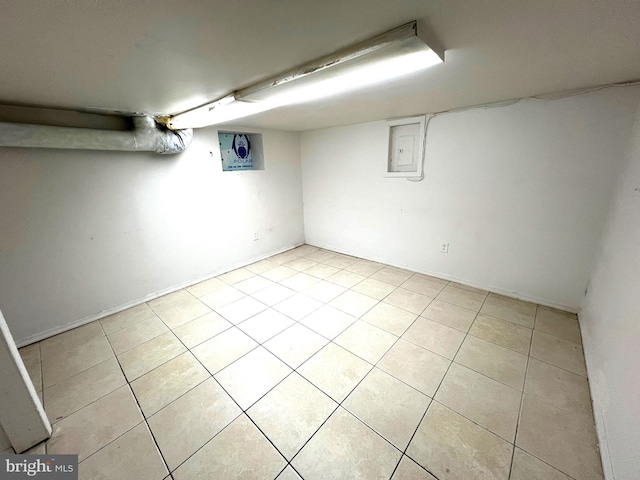 basement featuring light tile patterned floors and electric panel