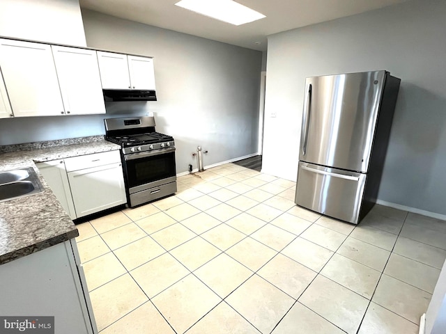 kitchen featuring light tile patterned floors, appliances with stainless steel finishes, and white cabinets