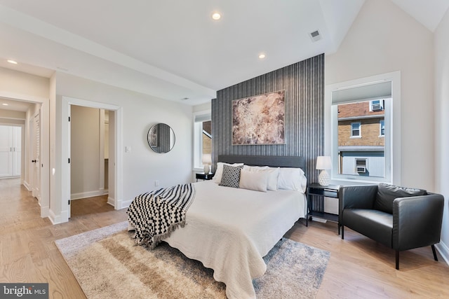 bedroom featuring vaulted ceiling and light hardwood / wood-style flooring