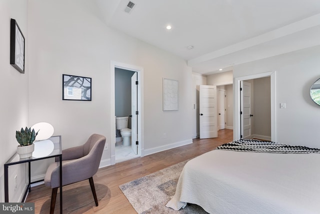 bedroom featuring ensuite bath and hardwood / wood-style floors