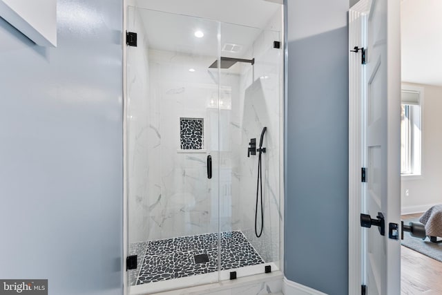 bathroom featuring a shower with door