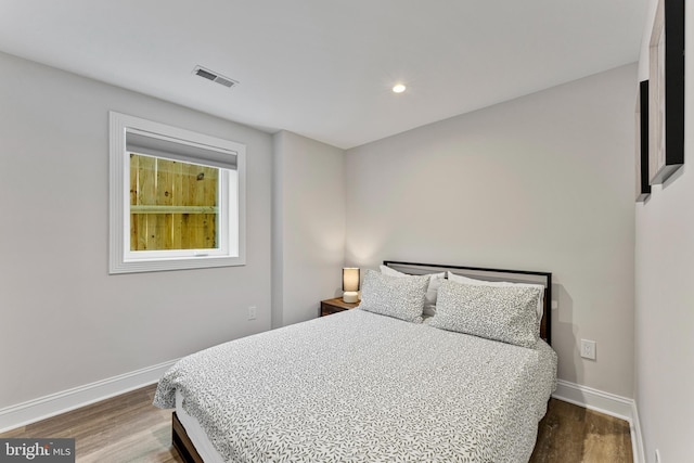 bedroom with dark hardwood / wood-style floors