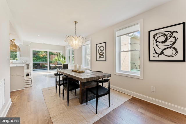 dining room featuring a notable chandelier and light wood-type flooring