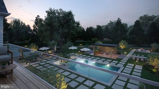 pool at dusk with a diving board and a patio area