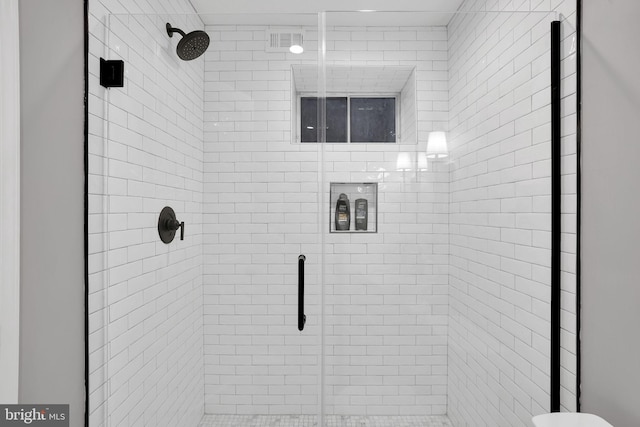 bathroom with a shower with shower door and toilet