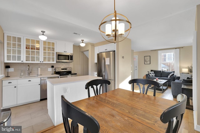 dining space featuring sink and an inviting chandelier