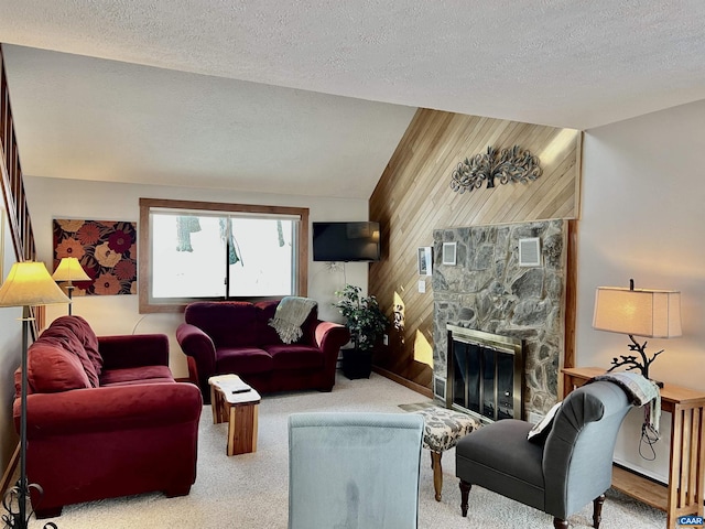 living room with carpet floors, a stone fireplace, wooden walls, and a textured ceiling