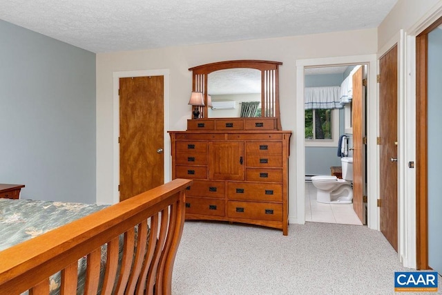 carpeted bedroom featuring connected bathroom and a textured ceiling