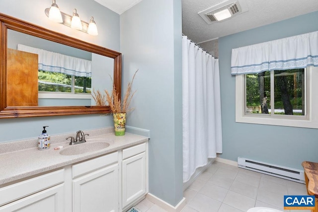 bathroom with a baseboard heating unit, a wealth of natural light, tile patterned floors, and vanity