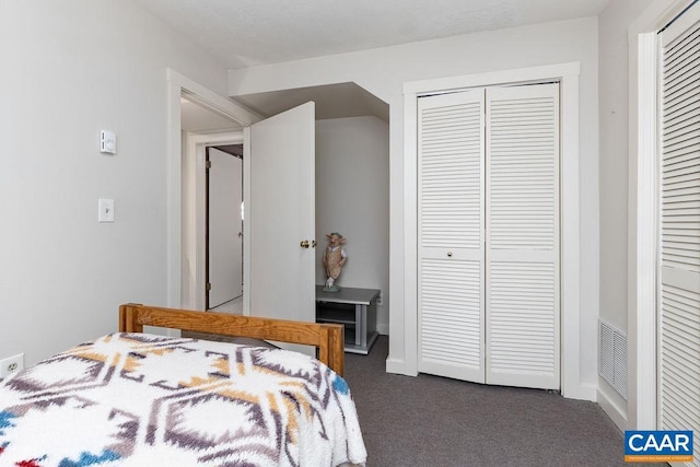 bedroom with a closet and dark colored carpet