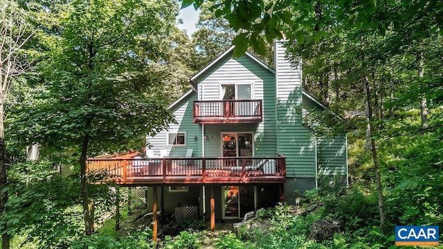 rear view of house with a balcony and a wooden deck