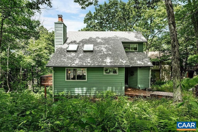 rear view of property featuring a wooden deck