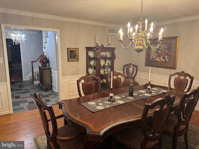 dining space featuring ornamental molding, a chandelier, and hardwood / wood-style floors