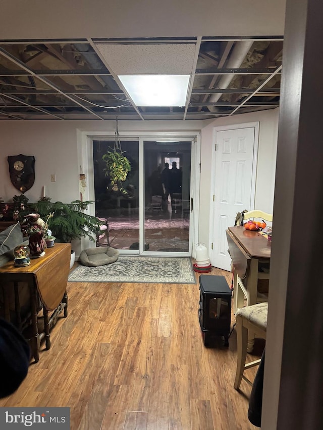 basement with a wood stove and hardwood / wood-style flooring