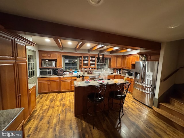 kitchen featuring decorative light fixtures, backsplash, a center island, a breakfast bar area, and stainless steel appliances