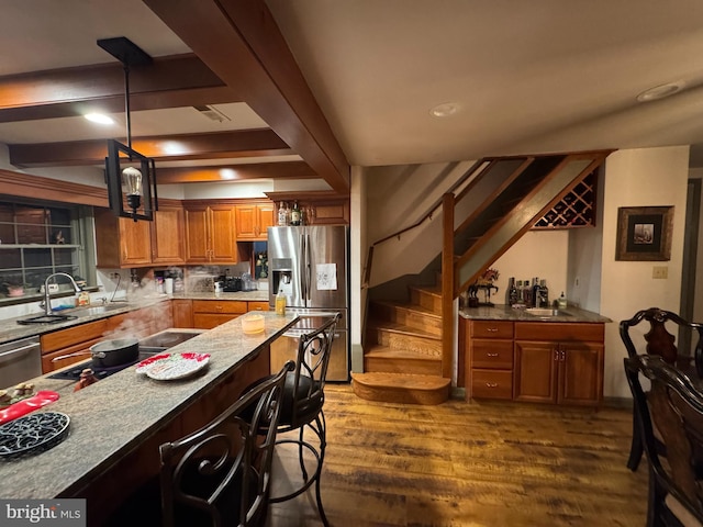 kitchen featuring decorative light fixtures, sink, dark hardwood / wood-style floors, and stainless steel appliances