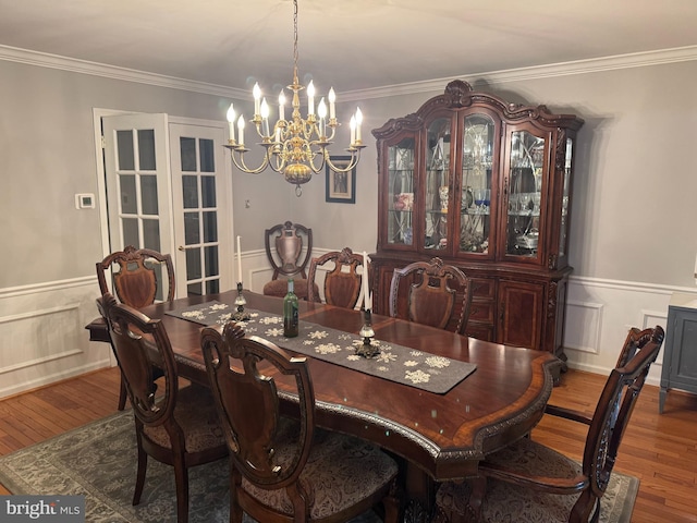 dining room featuring an inviting chandelier, crown molding, and hardwood / wood-style floors