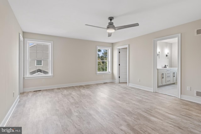 unfurnished bedroom with ceiling fan, sink, ensuite bathroom, and light hardwood / wood-style floors