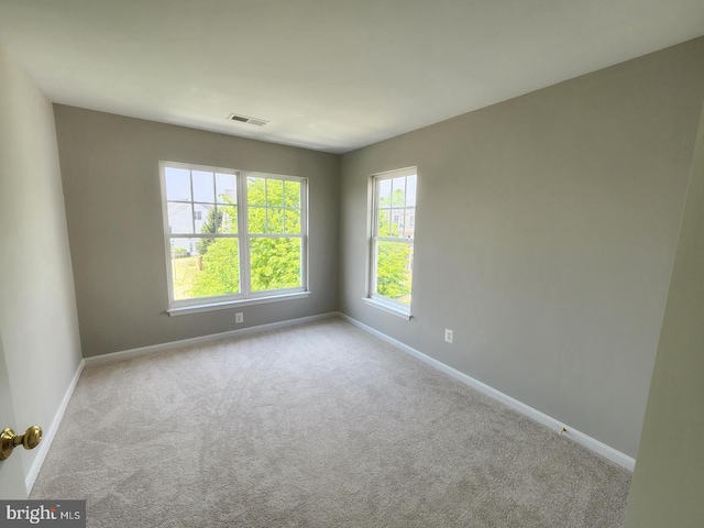 carpeted empty room with visible vents and baseboards