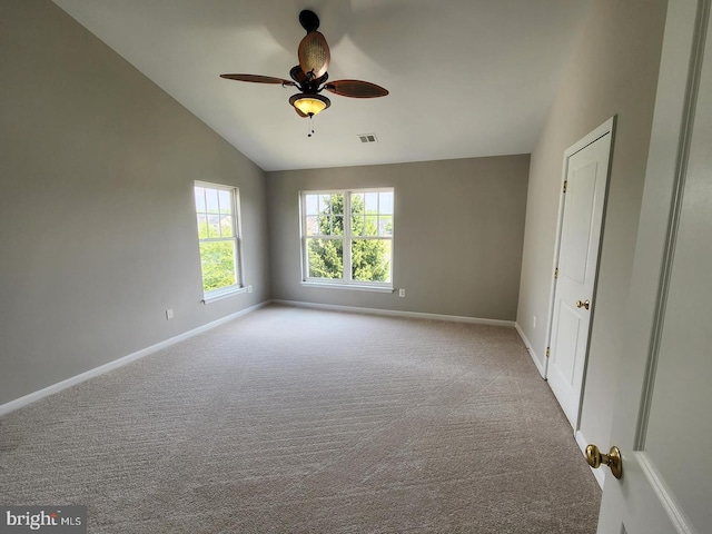 carpeted spare room with visible vents, a ceiling fan, lofted ceiling, and baseboards