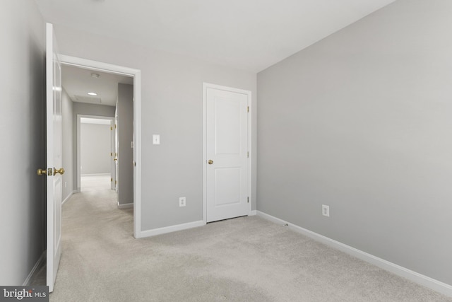 unfurnished bedroom featuring light colored carpet and baseboards