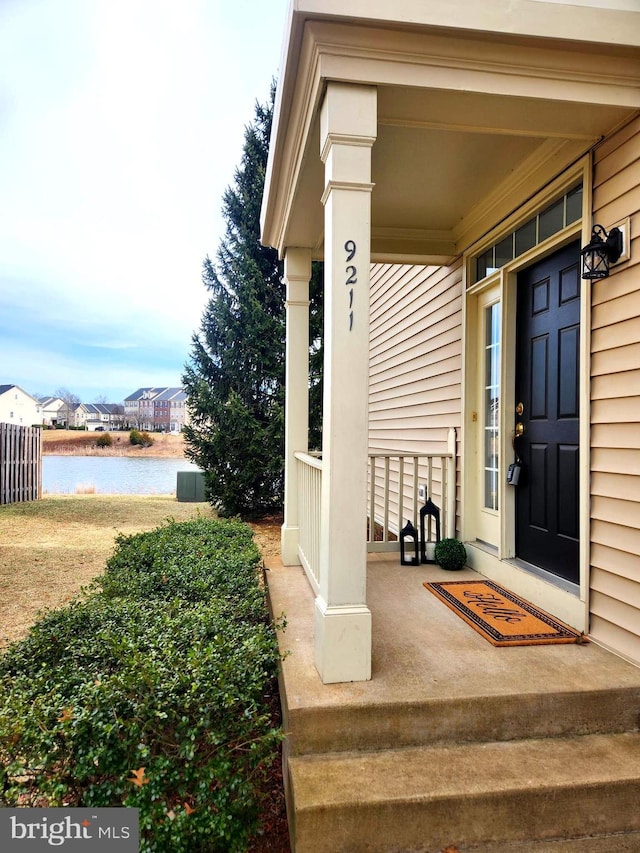 doorway to property with covered porch and a water view