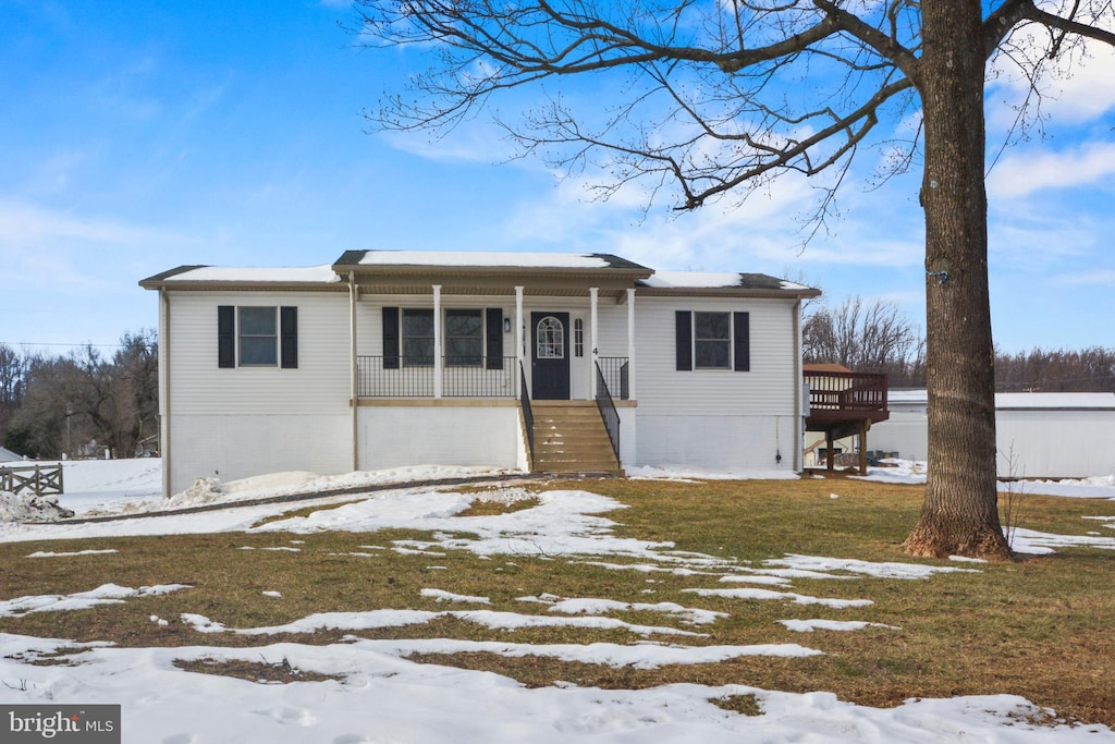 view of front of home with covered porch and a yard