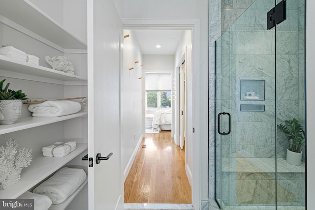 bathroom with hardwood / wood-style flooring and an enclosed shower