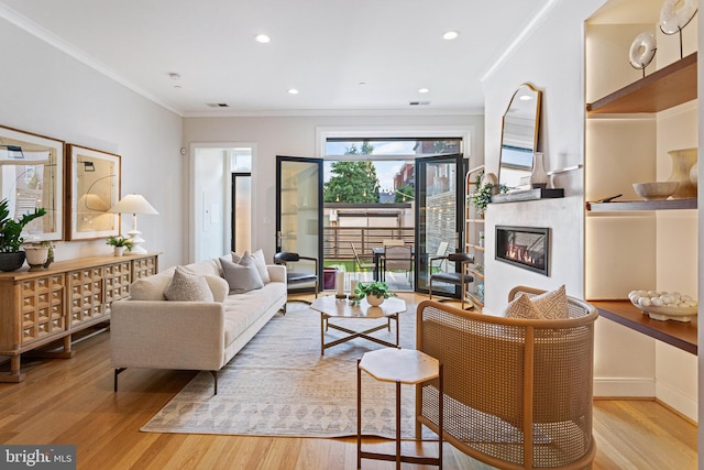 living room featuring light wood-type flooring and ornamental molding