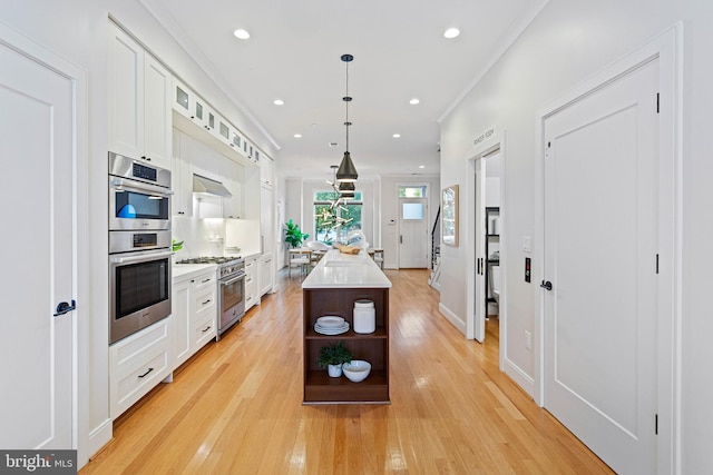 kitchen with white cabinetry, a center island, hanging light fixtures, and stainless steel appliances